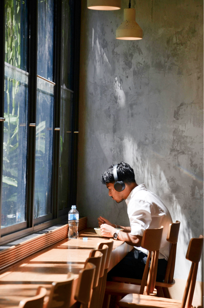 Student studying with headphones at a sunlit table