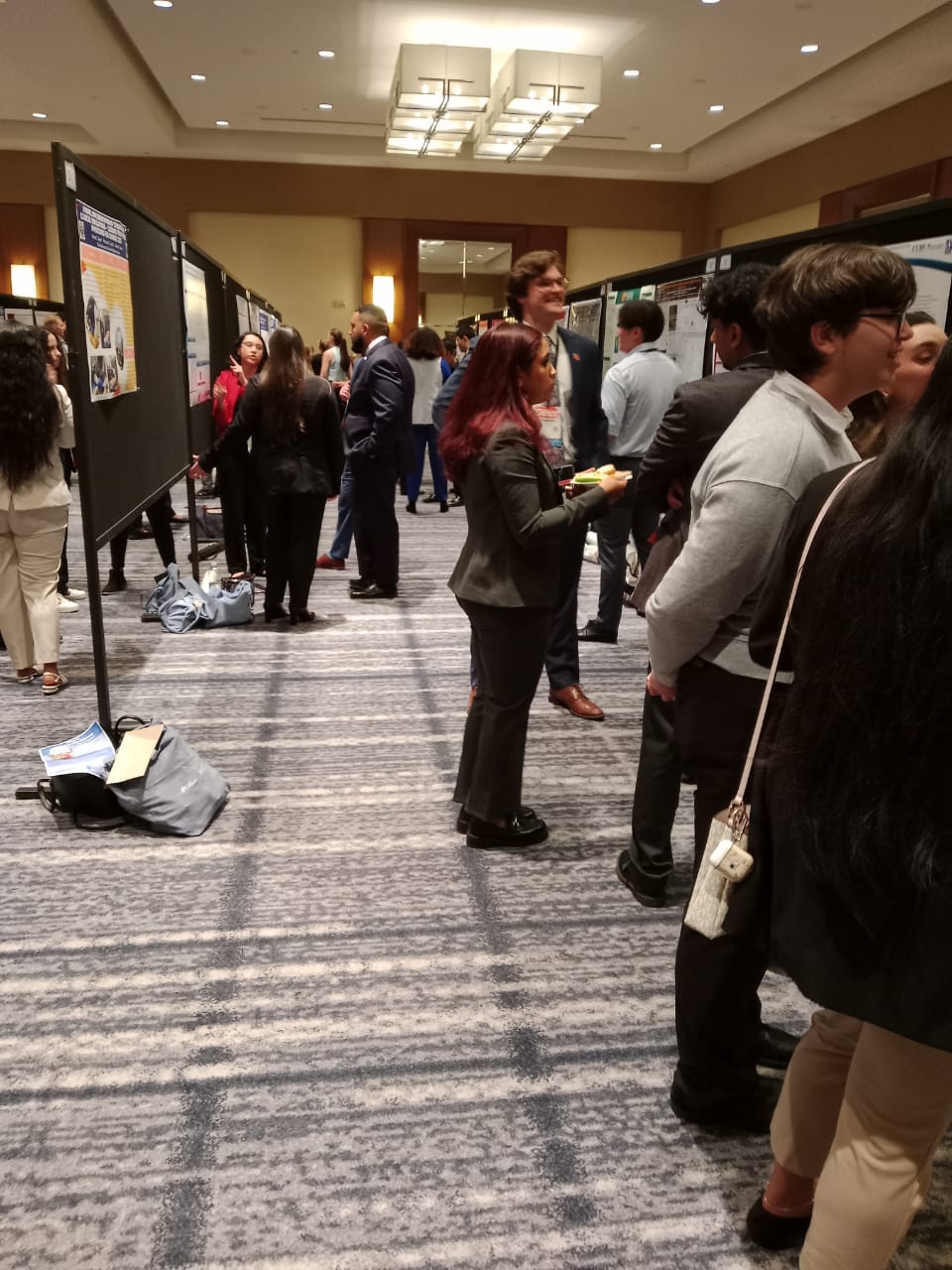 Students talking beside poster boards at a medical conference