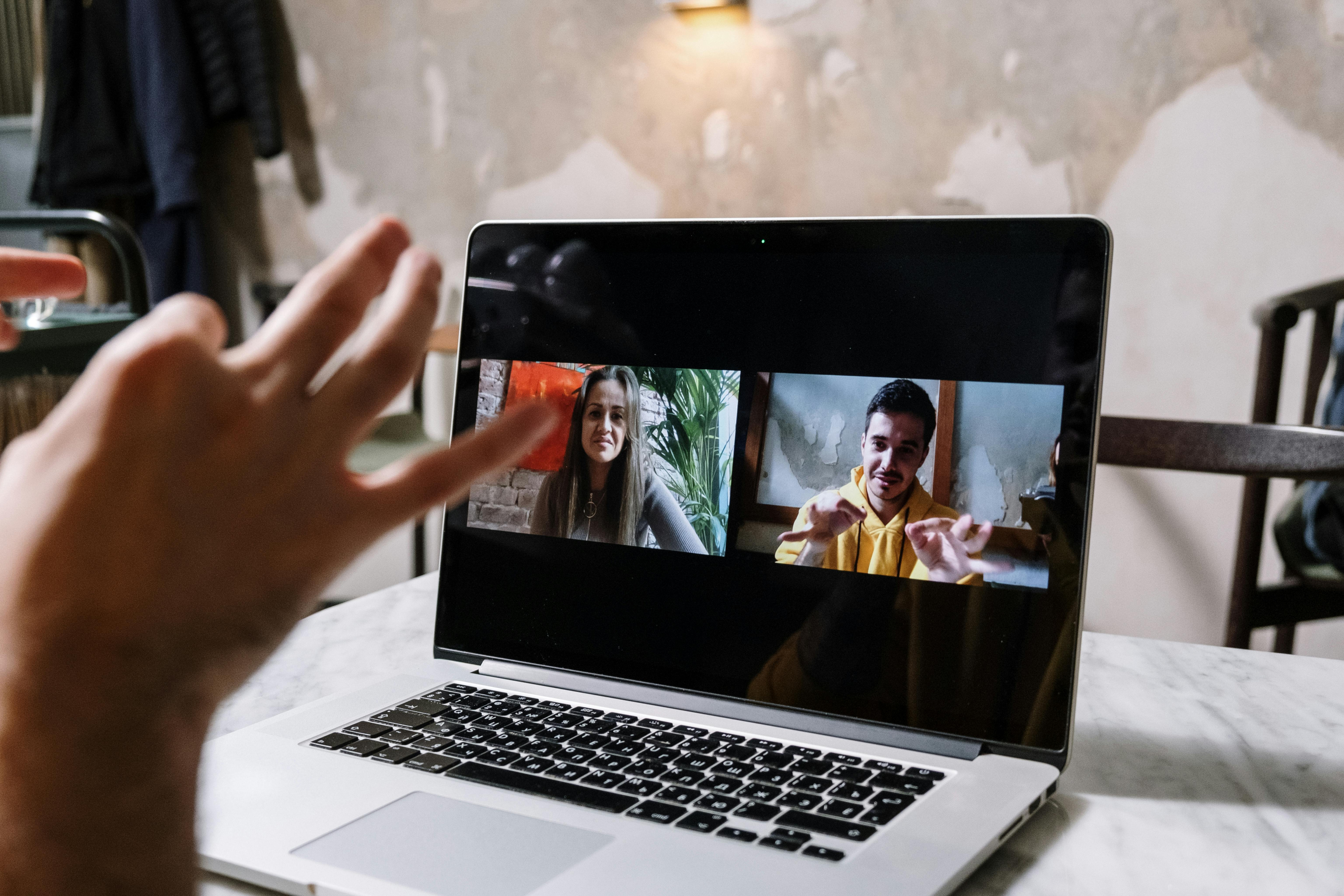 A laptop on a video call with two people